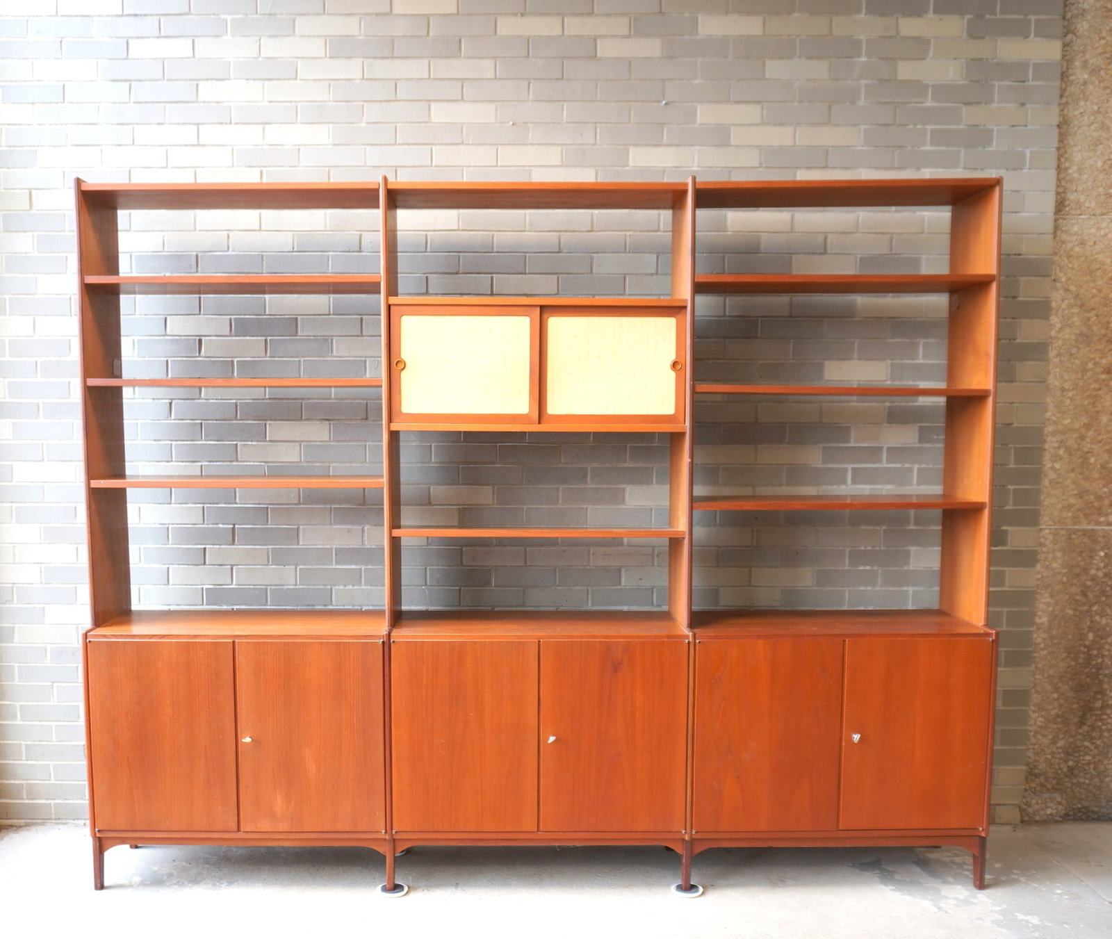 A mid-century modern style Norwegian teakwood sectional wall unit, composed of 3 sections. The far (1 of 11)