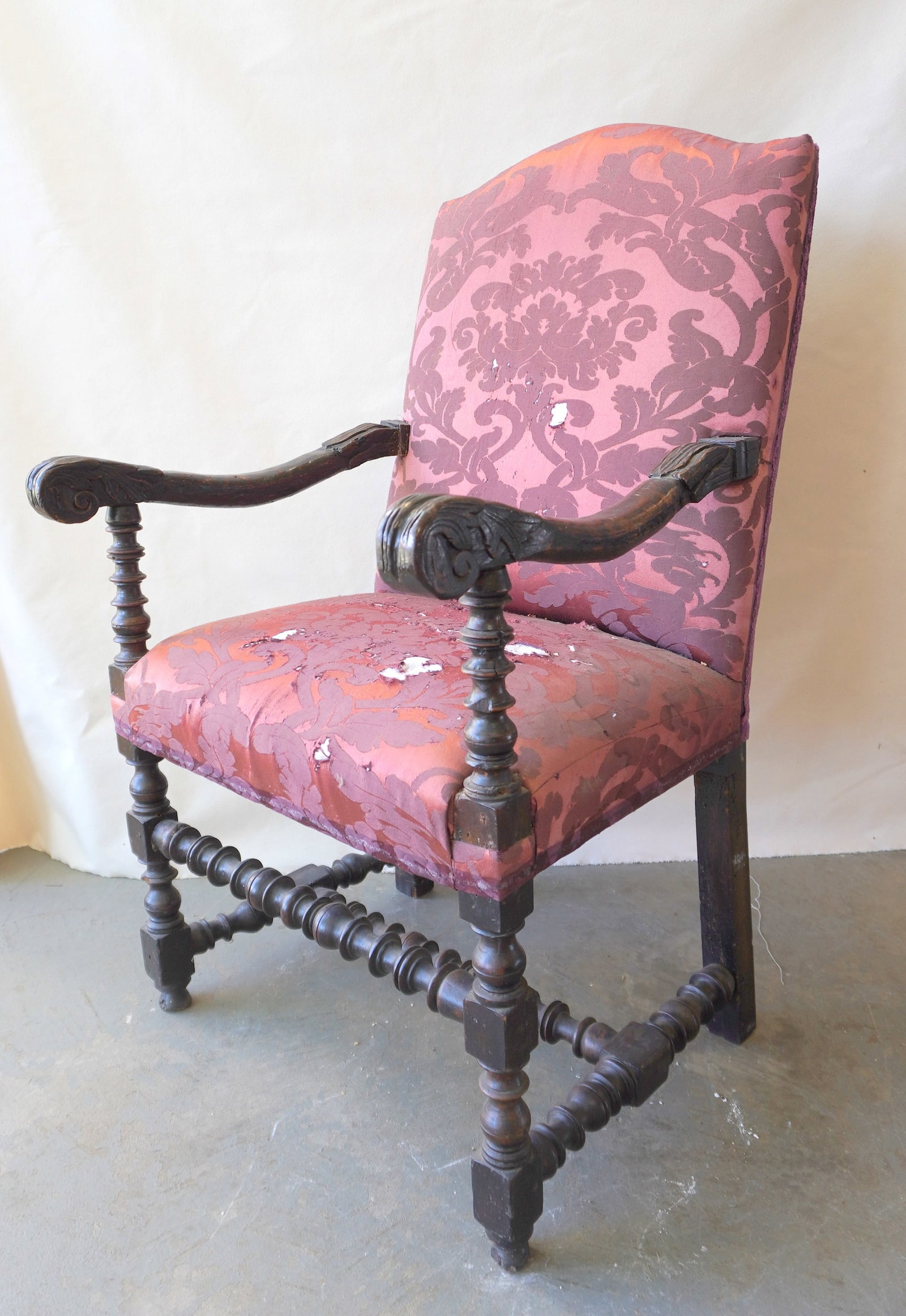 An early heavily carved European armchair, probably Italian, late 17th to early 18th century. The: An early heavily carved European armchair, probably Italian, late 17th to early 18th century. The arms with acanthus carvings and the stretchers with extensive spool turnings, and having original butt