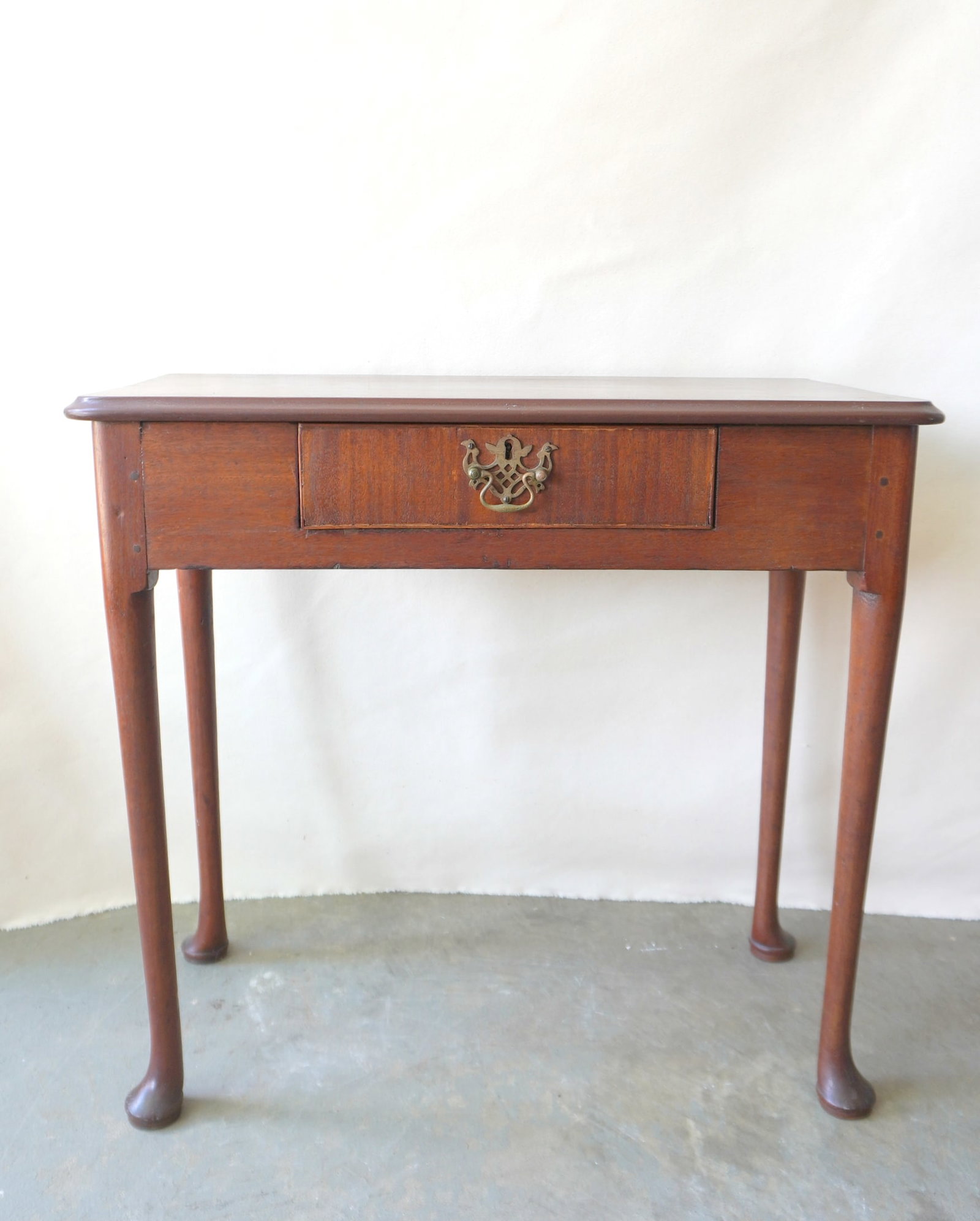 A mahogany Queen Ann work table with single drawer, carbriole legs leading to Dutch feet, 18th: A mahogany Queen Ann work table with single drawer, carbriole legs leading to Dutch feet, 18th century. The top is possibly a replacement, but otherwise in good condition. Measures 29 3/4"W x 14 3/4"D