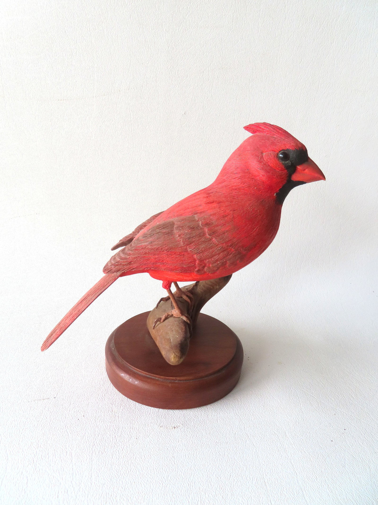 A hand carved and painted Cardinal bird perched on branch, in original paint, and signed Robert &: A hand carved and painted Cardinal bird perched on branch, in original paint, and signed Robert & Virginia Warfield, Jaffrey, NH., dated 1979 - measures 6 3/4"H x 6 1/2"W, and in very good condition. 