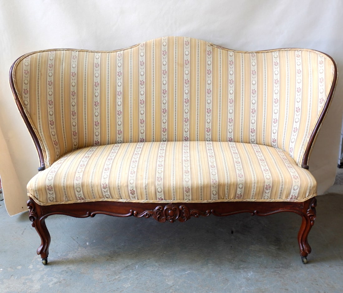 A beautiful upholstered Victorian love seat decorated in a newer striped vertical pattern and with: A beautiful upholstered Victorian love seat decorated in a newer striped vertical pattern and with carved mahogany frame and cabriole legs, circa 1860-80. Very slight wear along the top edge upholster