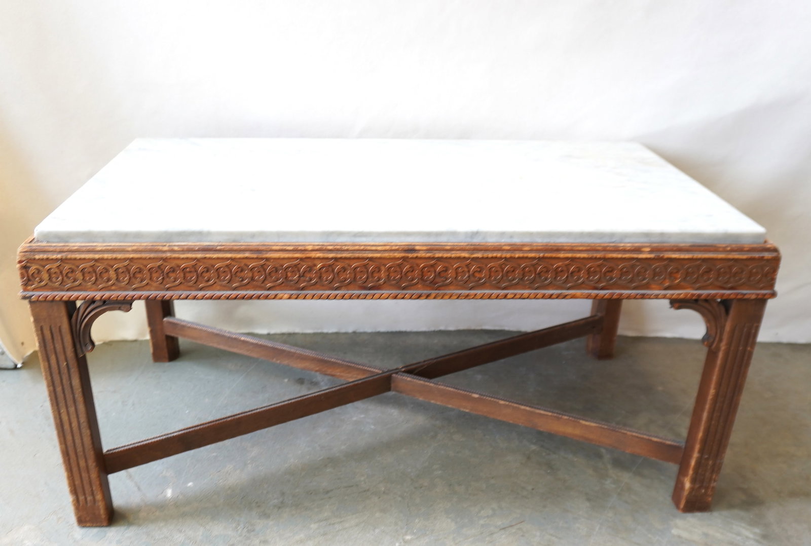 A Chippendale style carved wooden coffee table with marble top, fluted legs and cross stretchers, (1 of 7)