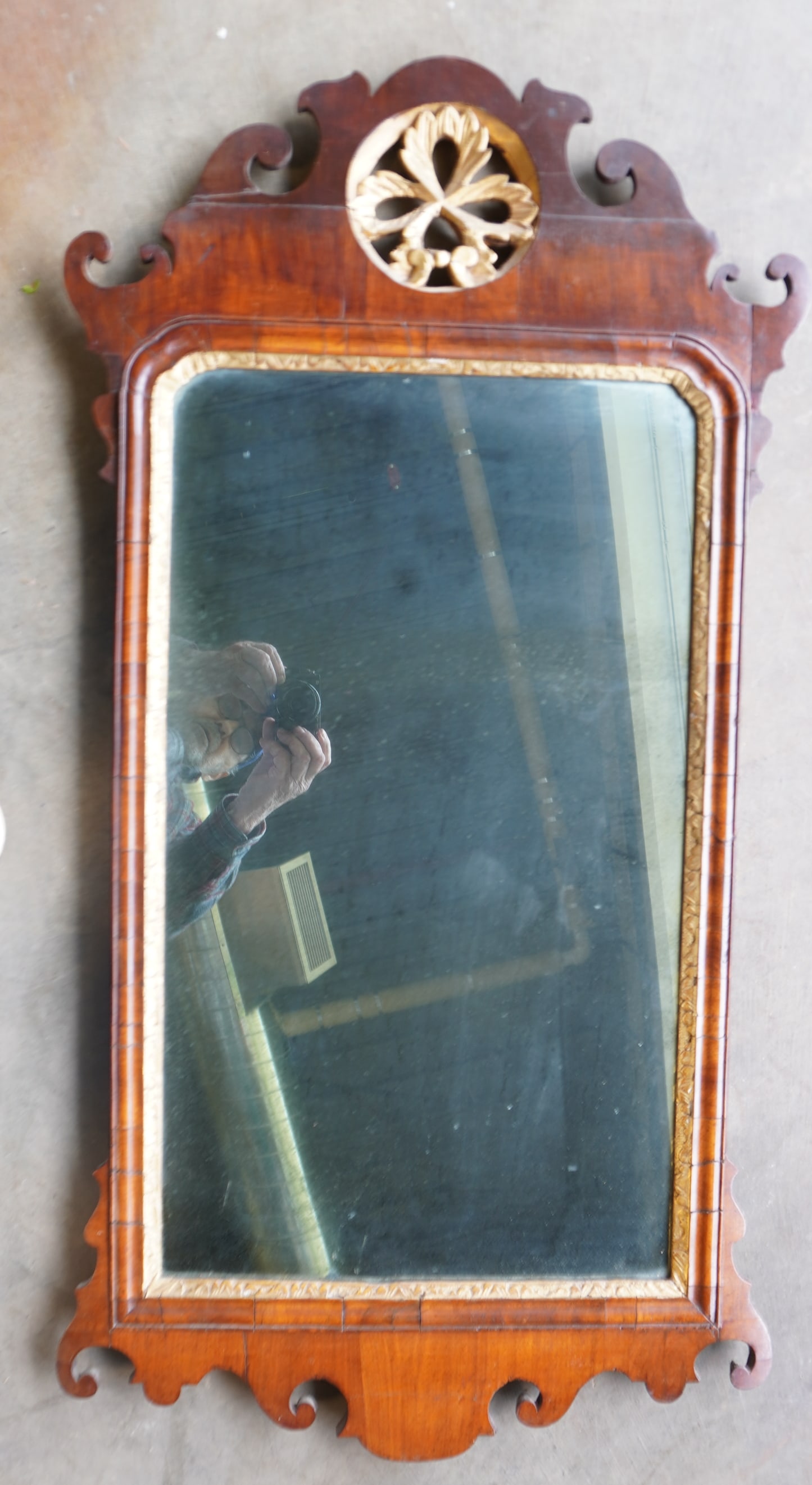 A Chippendale mahogany looking glass, having a crest with a central pierced carved flower, and also: A Chippendale mahogany looking glass, having a crest with a central pierced carved flower, and also having a gilt wood inset around mirror, late 18th to early 19th century. Note the presence of a part
