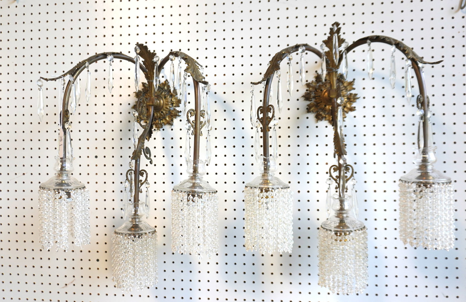 A fancy pair of French style bronze wall sconces having 3 arms with applied leaf decorations on the: A fancy pair of French style bronze wall sconces having 3 arms with applied leaf decorations on the larger outer arms and central smaller arm decorated with scrolls and leaf designs - all 3 arms and f