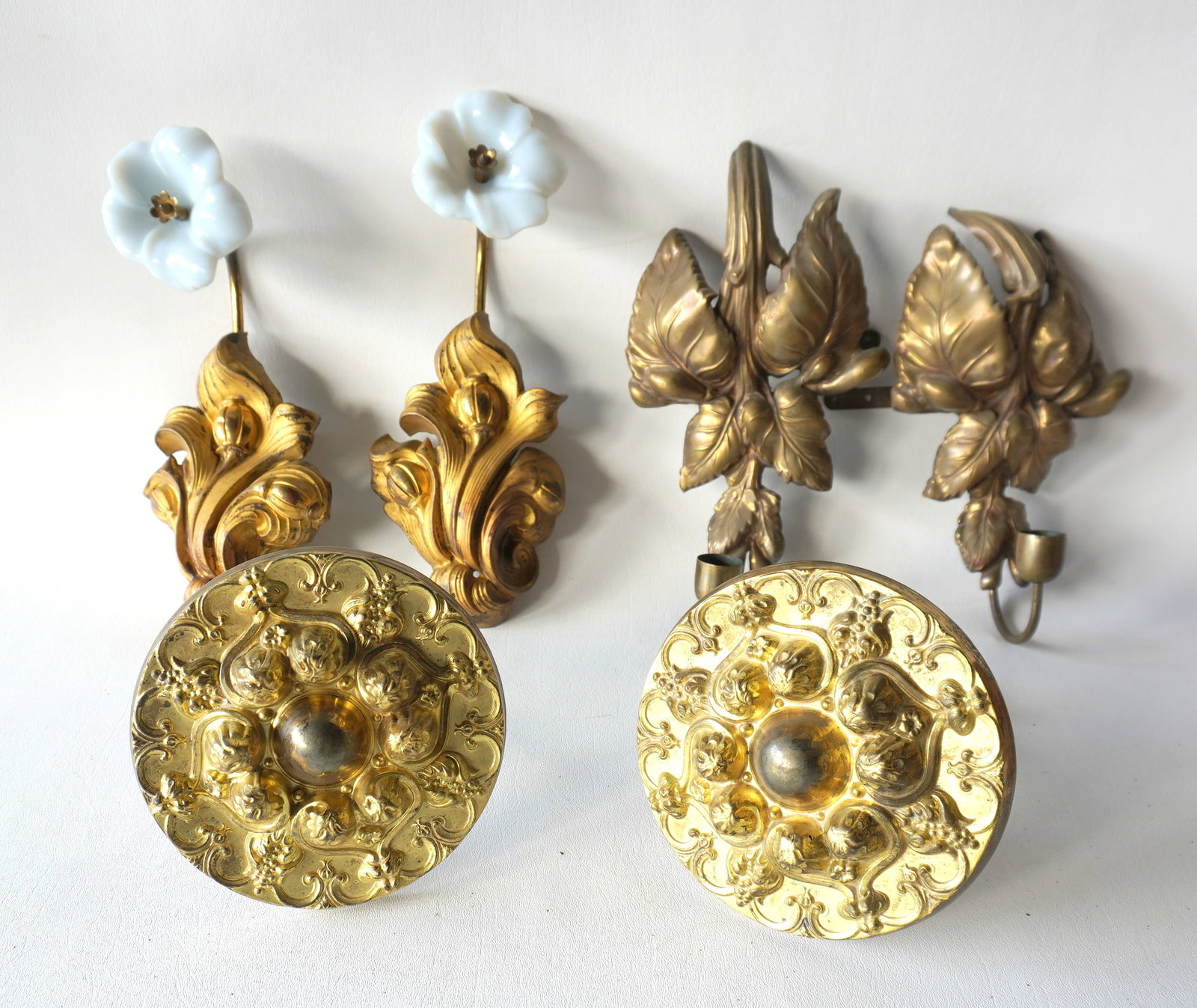 Three 19th century pressed brass wall/curtain ornaments including: Pair of floral shaped tie-backs: Three 19th century pressed brass wall/curtain ornaments including: Pair of floral shaped tie-backs with attached white opalescent glass flowers - each in good condition and measures 10 1/2"H x 4 1/2"W