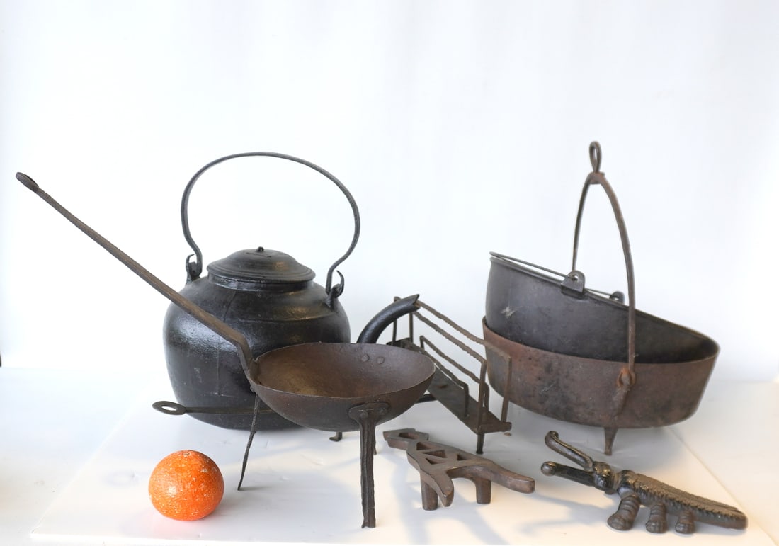 Grouping of early wrought and cast iron hearth objects including: Two cast iron bootjacks, one (1 of 8)