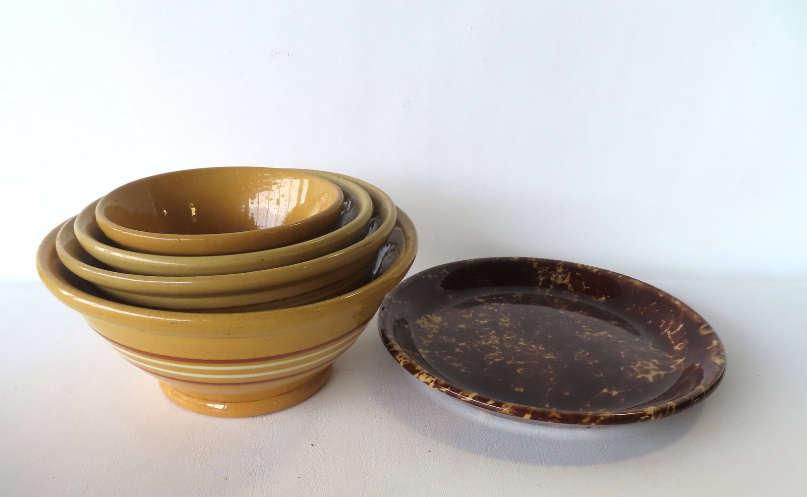 A matching nested set of 4 yellowware footed mixing bowls - ranging in size from 6 3/4" diameter x 3 (1 of 7)