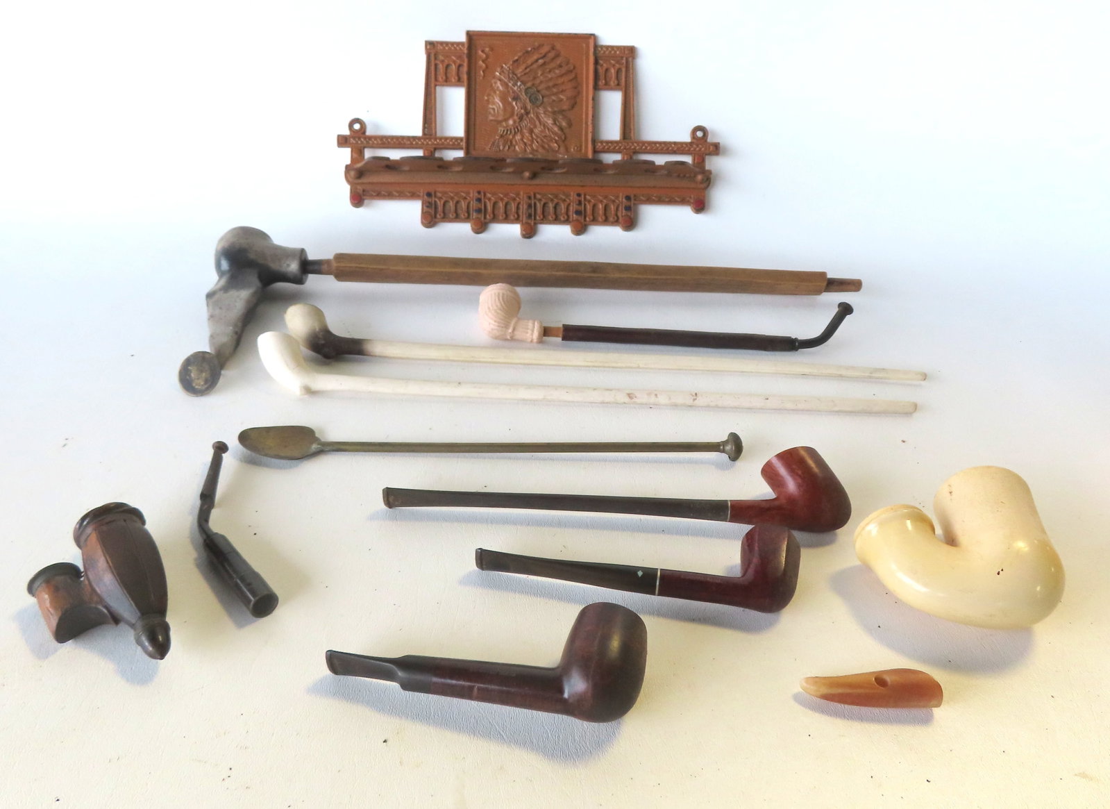 A grouping of smoking pipes & a cast iron pipe holder decorated with an embossed Indian Chief in (1 of 9)
