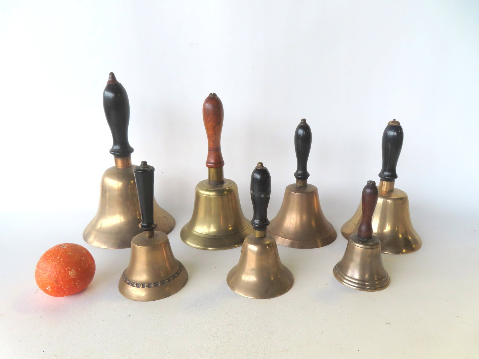 A grouping of 9 vintage brass school bells, all with turned wooden handles, most late 19th to early (1 of 8)