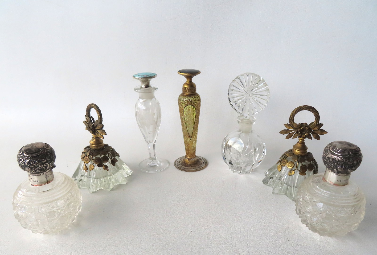 A grouping of 7 perfume & scent bottles. Includes 2 matching perfumes in cut glass with sterling (1 of 20)