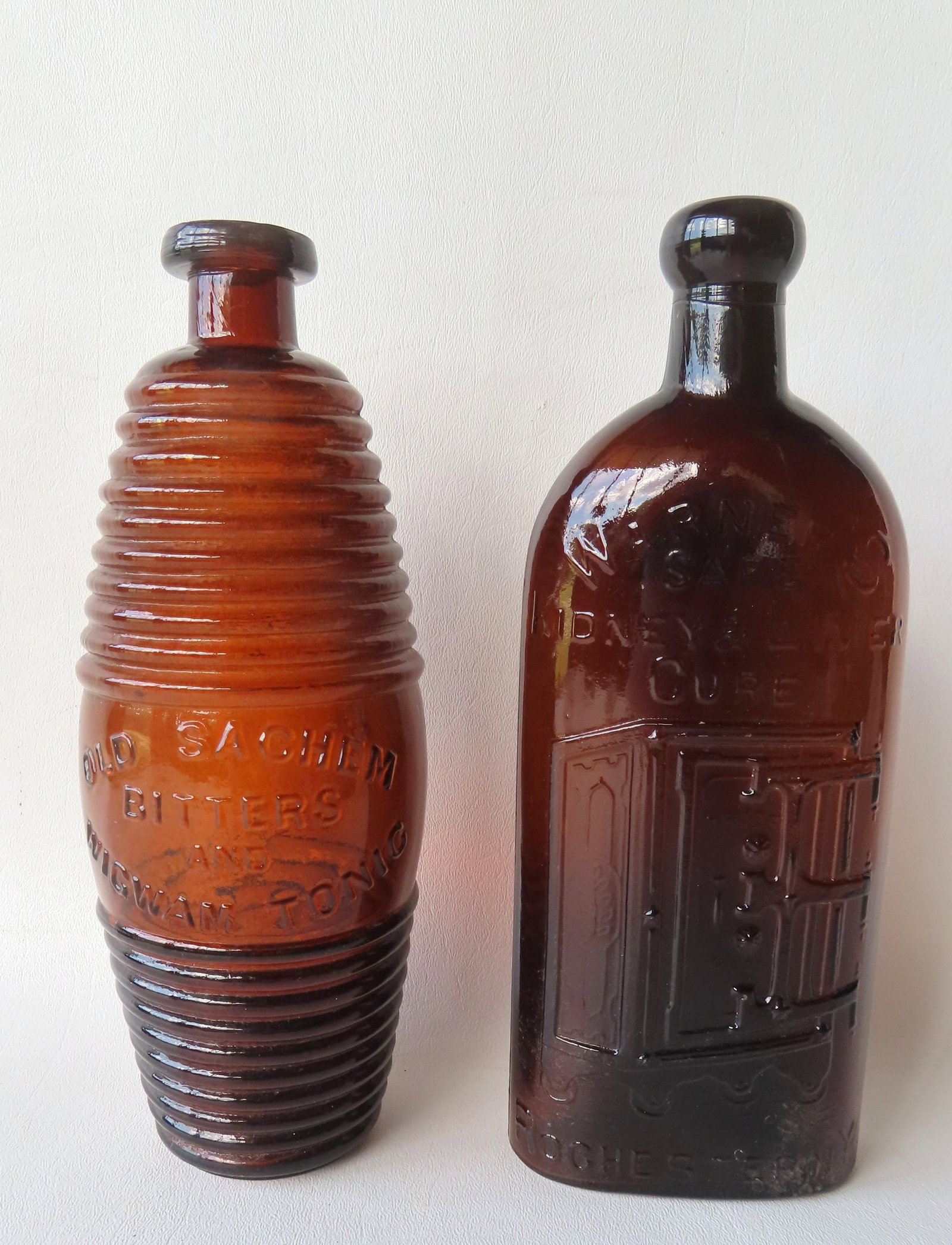 Two vintage medicinal bottles: The first a figural barrel shaped bitters bottle signed "Old Sachem / (1 of 9)