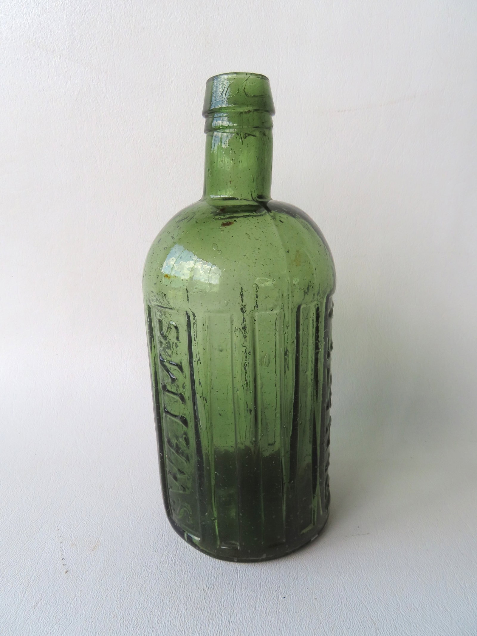 Medicine bottle marked "Swaim's / Panacea / Philada", light green, many small bubbles, deep scared: Medicine bottle marked "Swaim's / Panacea / Philada", light green, many small bubbles, deep scared pontil, tapered collared mouth above irregular ring with small chip likely from process. Overall very