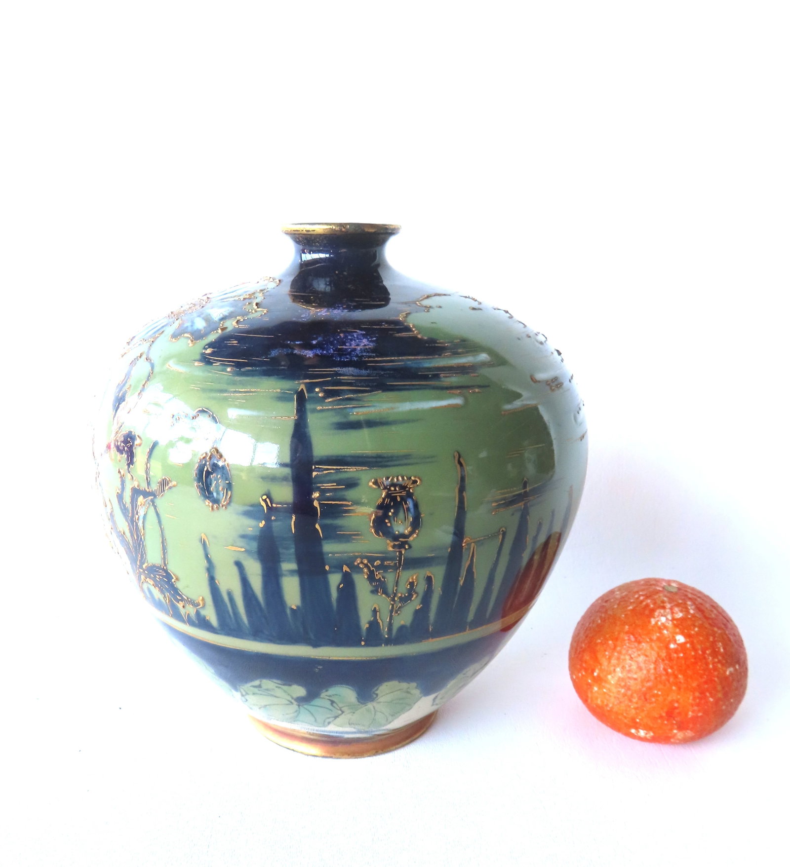 A signed "Turn-Tepliz Bohemia RStK" vase decorated with hand painted flowers, leaves and stylized: A signed "Turn-Tepliz Bohemia RStK" vase decorated with hand painted flowers, leaves and stylized trees or buildings extending into sky - loss to flared rim that needs repair, else good condition (see