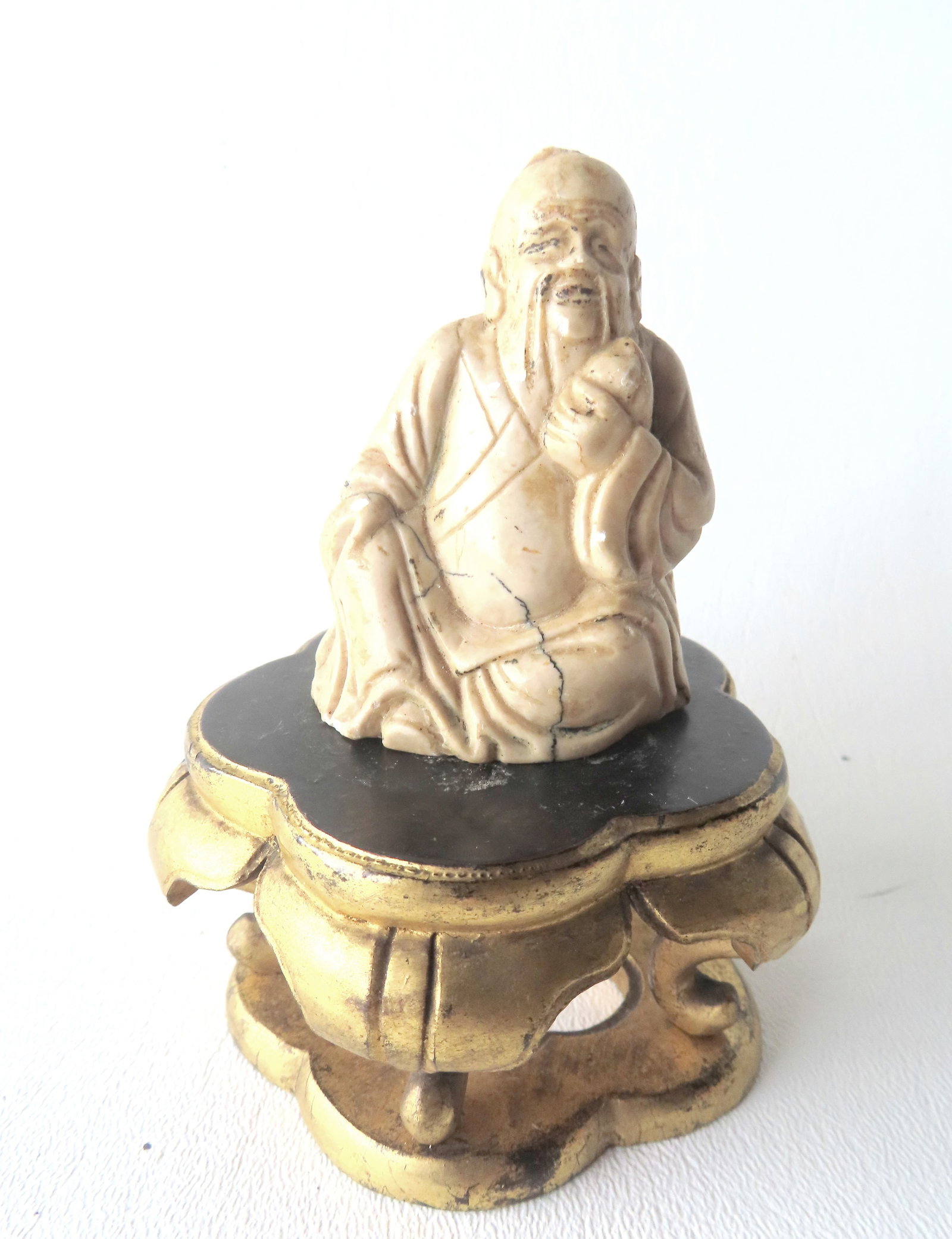 A small Chinese carved stone sculpture of a seated Buddha holding an unknown item in his left hand - (1 of 7)