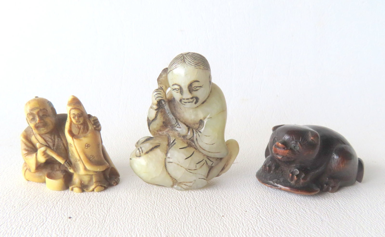 Grouping of 3 netsukes including: Stone sculpture of oriental gentleman seated on frog-like figure (1 of 10)