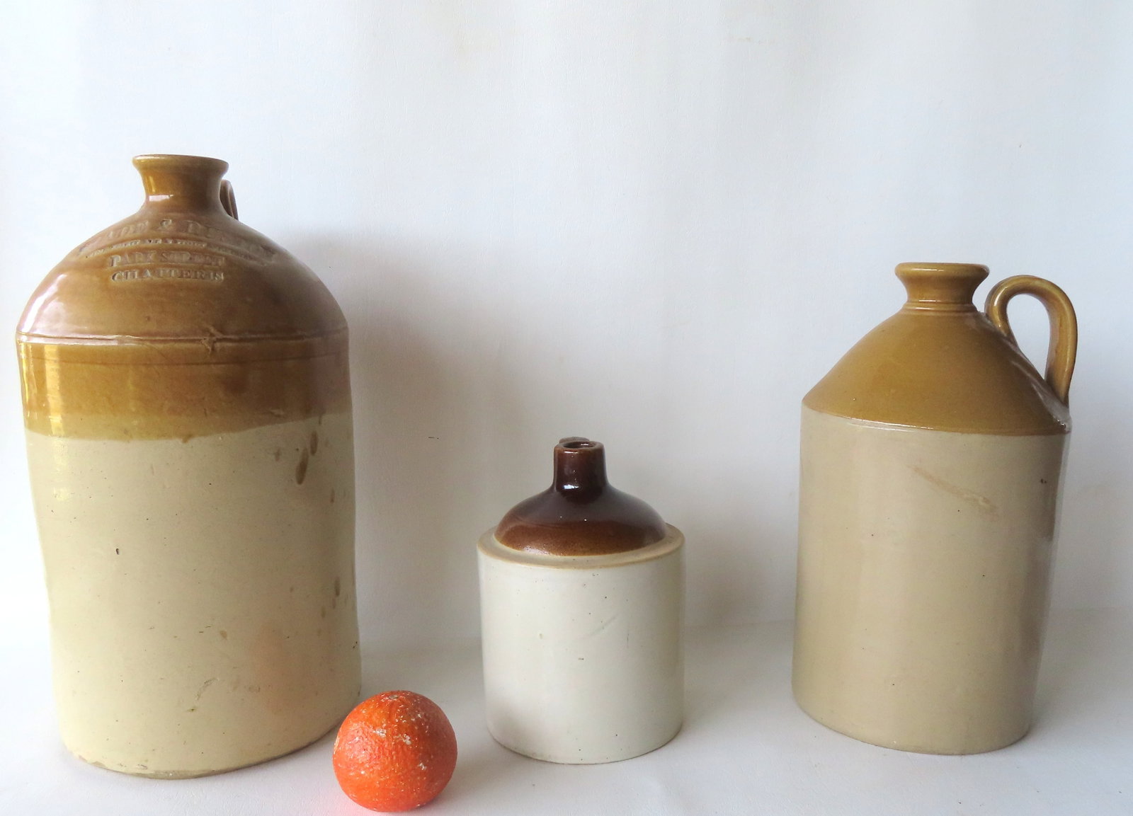 Three stoneware jugs including an English advertising spirits jug with light brown slip impressed (1 of 4)
