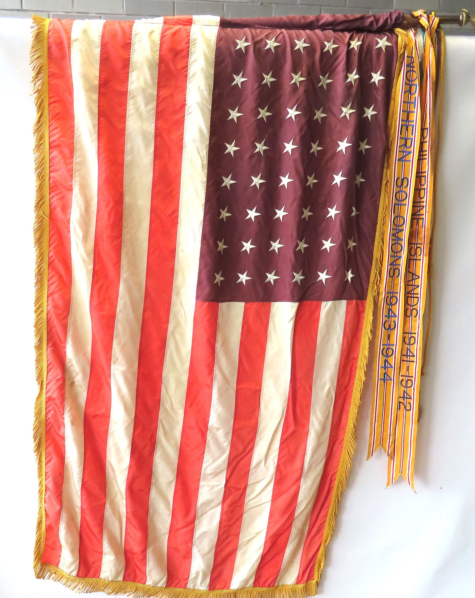 A WWII 48 star commemorative campaign flag with applied gold fringe, having 3 attached banners,: A WWII 48 star commemorative campaign flag with applied gold fringe, having 3 attached banners, circa 1946. The first banner "Phillipine Islands 1941-1942"; the second "Northern Solomons" 1943-1944; a
