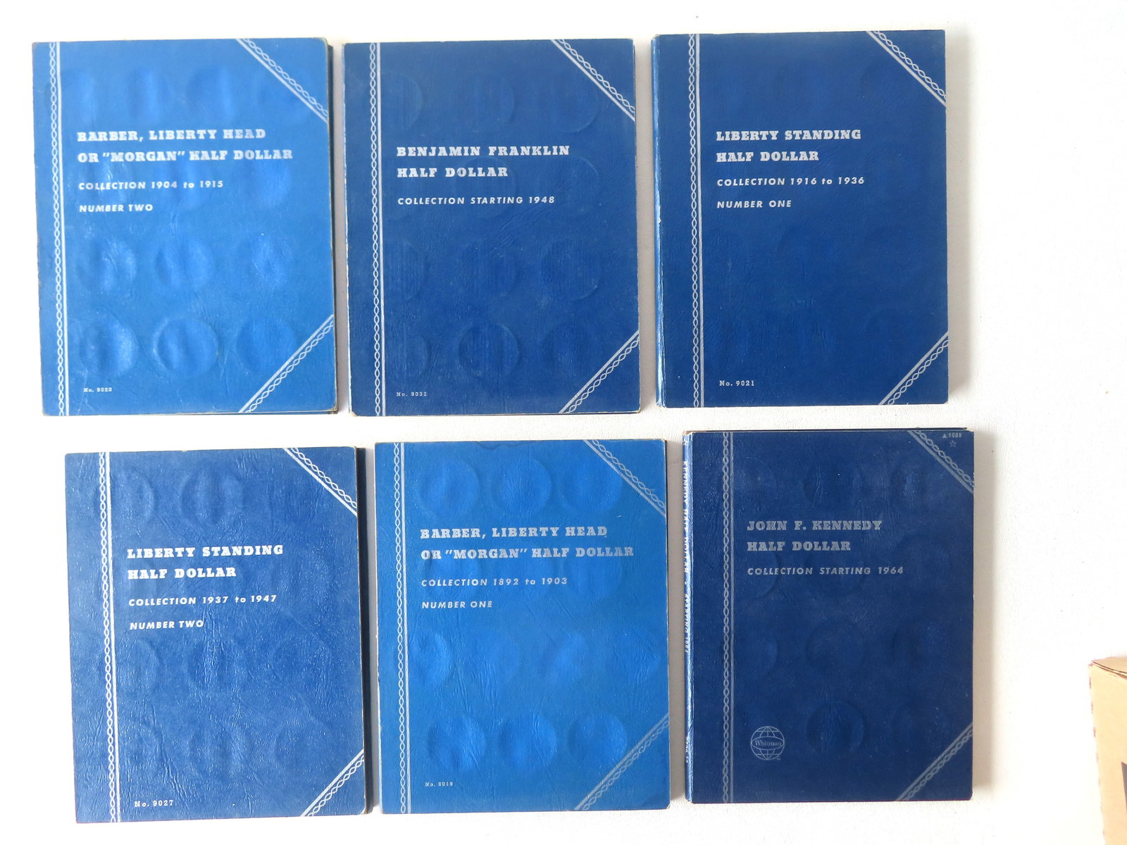 A grouping of 122 American half dollars housed within 6 books. Includes: Liberty Standing Half: A grouping of 122 American half dollars housed within 6 books. Includes: Liberty Standing Half Dollar Collection 1916 to 1936 (Number One) - 22 coins; Liberty Standing Half Dollar Collection 1937 to 1