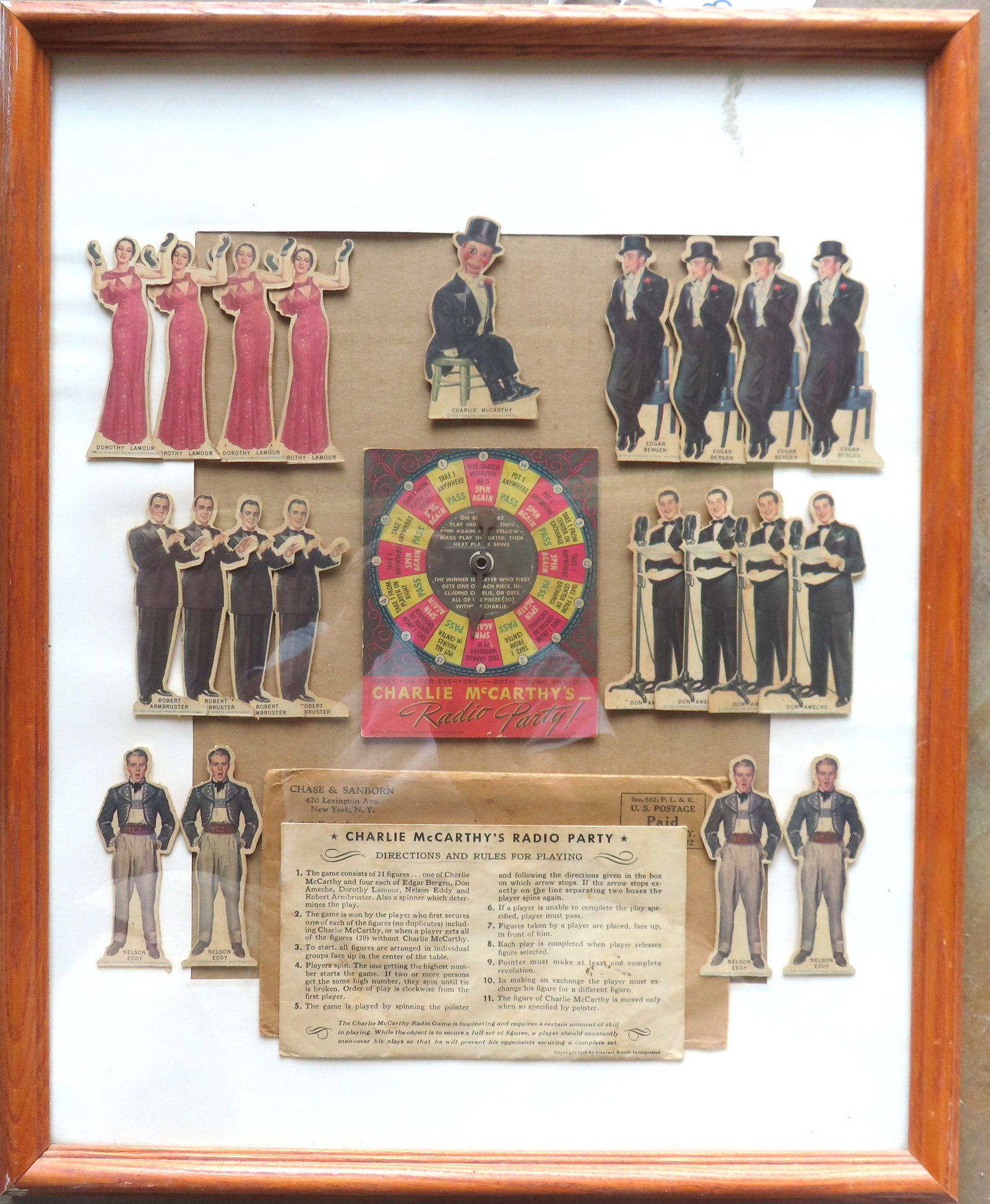 A framed lithographed cardboard game "Charlie McCarthy's Radio Party", with spinner and all the: A framed lithographed cardboard game "Charlie McCarthy's Radio Party", with spinner and all the original cardboard standup figures. A premium toy mailed to recipient from Chase Sanborn company. Figure