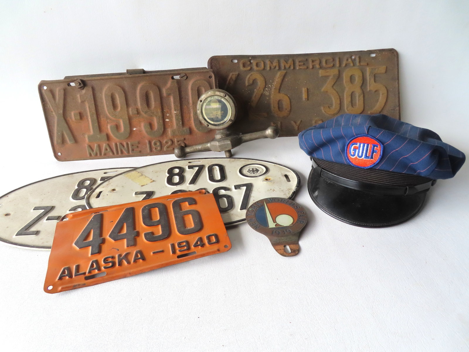 A grouping of vintage auto related collectibles including: 2 oval German vintage license plates: A grouping of vintage auto related collectibles including: 2 oval German vintage license plates marked "Hauptzollamt Stuttgart West" - good condition; Maine 1925 license plate - surface rust and needs