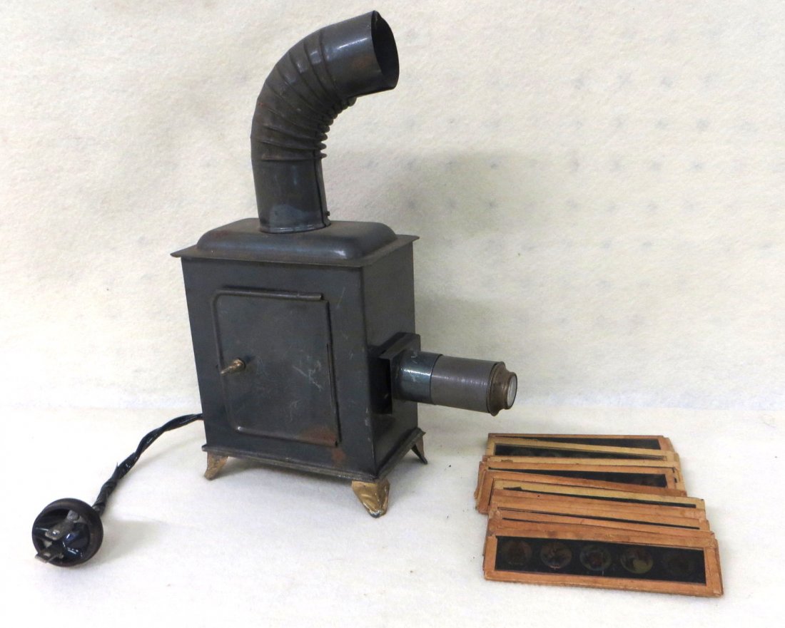 Toy electric tin lantern with 19 cartoon figure glass s: Toy electric tin lantern with 19 cartoon figure glass slides, circa 1920.