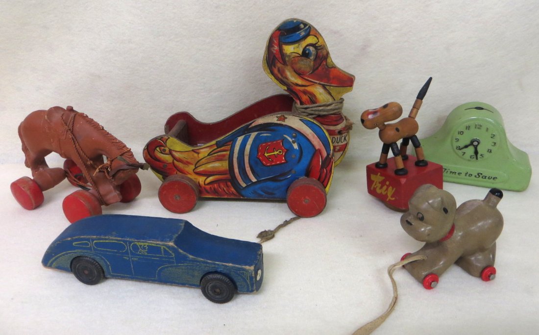 Lot of six toys including horse on wheels, Quacky Duck : Lot of six toys including horse on wheels, Quacky Duck #426, Trix dog, wooden car, painted tin savings bank in the form of a clock, and composition toy on wheels.
