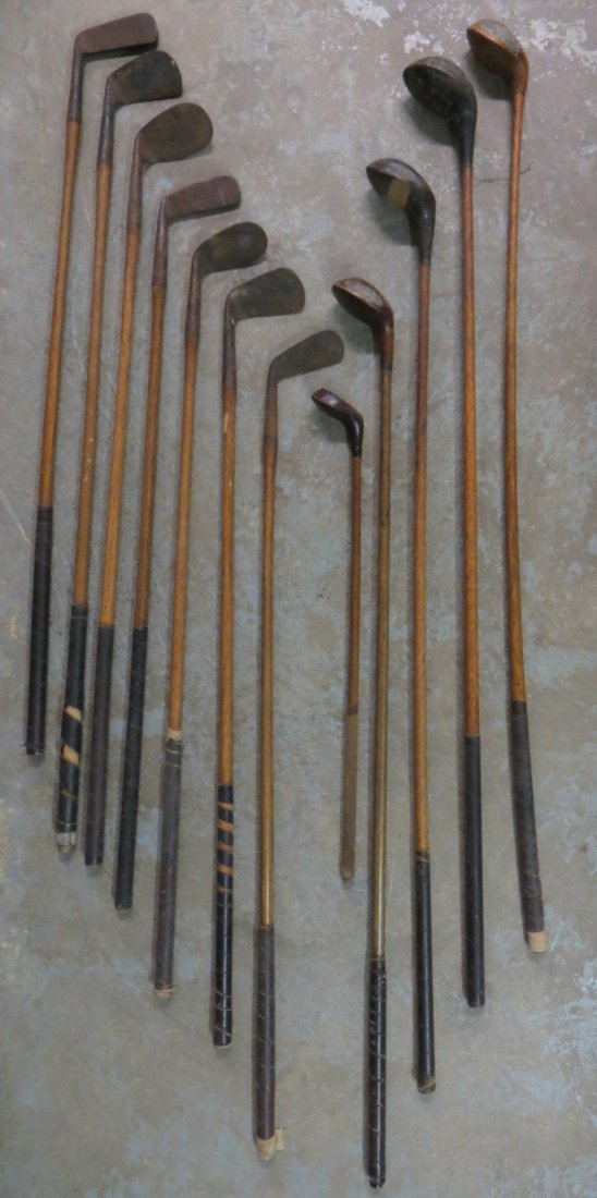Grouping of vintage golf clubs with wooden shafts inclu: Grouping of vintage golf clubs with wooden shafts including 1 child's driver, 4 adult drivers and 7 irons.