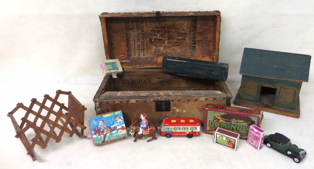 Early cow hide trunk with a grouping of miscellaneous o: Early cow hide trunk with a grouping of miscellaneous old toys including Donkey Boy windup in original box, 2 boxes sets of dominoes, tin Kindergarten bus, small block set in box, Pine Brook barn, Vic