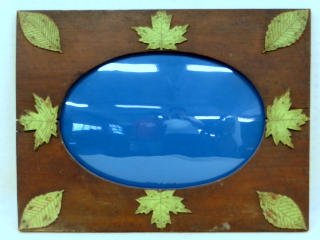 Wooden folk art rustic frame with convex oval glass and: Wooden folk art rustic frame with convex oval glass and applied green carved leaves - 18.5" x 13.5" (interior) - good condition but 2 slight wood separations under leaves in center of frame. Late 19th