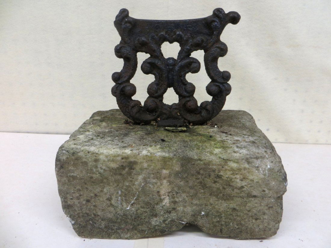 Cast iron lyre shaped boot scraper.: Cast iron lyre shaped boot scraper mounted in stone, probably limestone - early to mid-19th century - note loss to upper right corner of boot scraper.