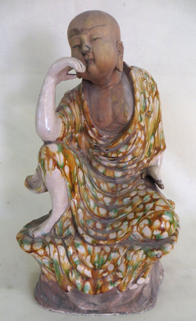 Earthenware figure of a seated Buddhist monk in mustard: Earthenware figure of a seated Buddhist monk in mustard colored drip glaze - 19"H - probably early 19th century.