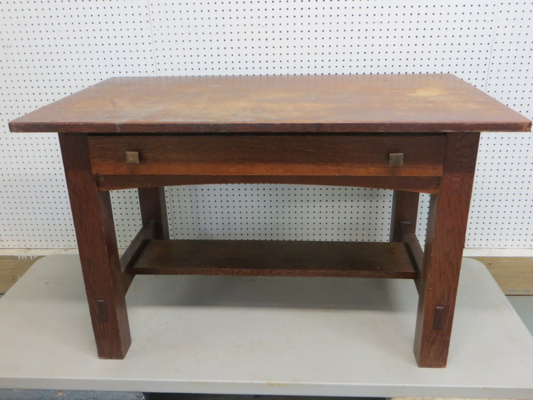 Signed Limbert oak desk with center drawer and lower: Signed Limbert oak desk with center drawer and lower shelf. 4'L x 28.25"W x 29.25"H. Desk with original finish, small surface impression in upper left corner, minor surface scratches, some staining - 