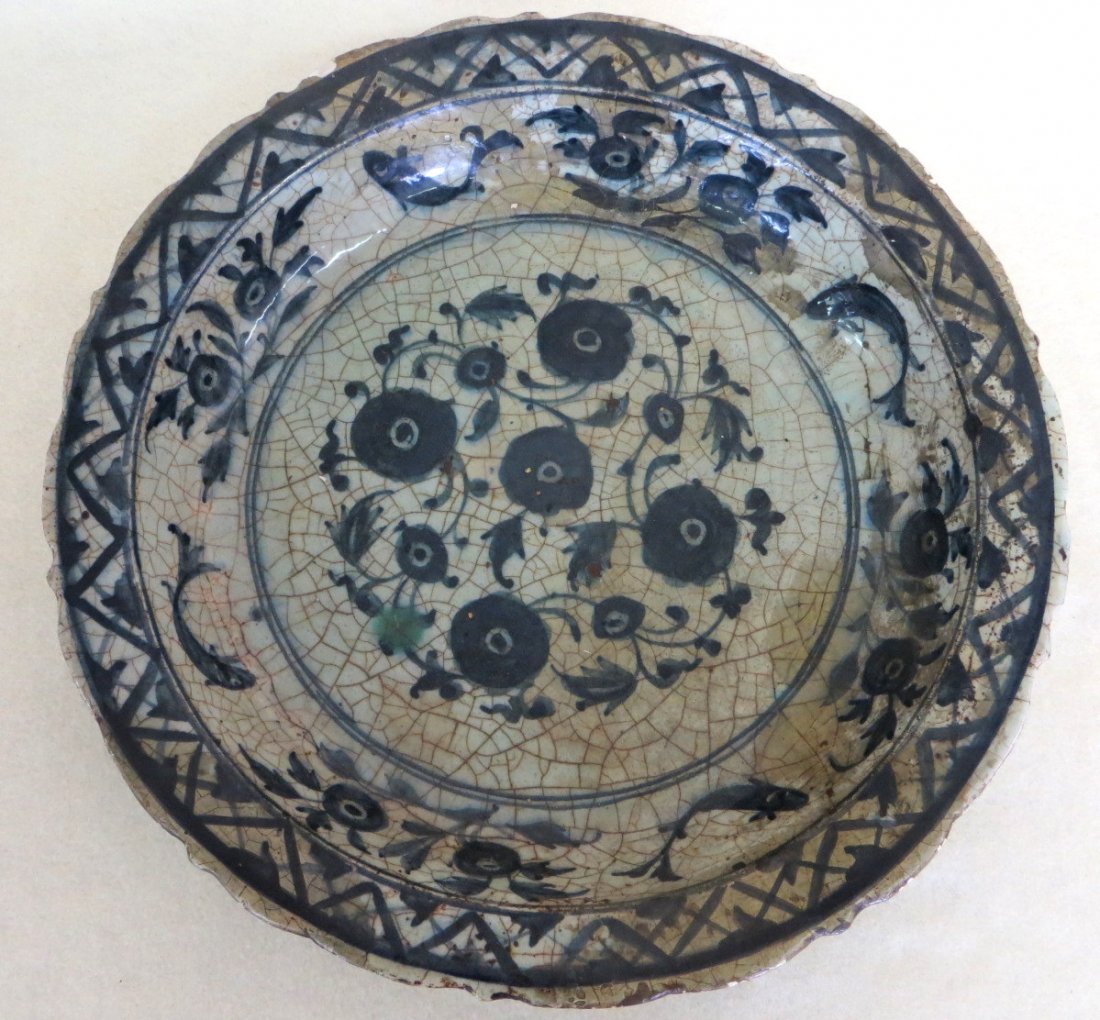 European 17th century or earlier, deep dish footed: European 17th century or earlier, deep dish footed porcelain charger hand decorated with flowers and fish in blue and white, possibly Delft. 13.25"D x 2.50"H. Minor chips to rim, extensive crazing. Pr