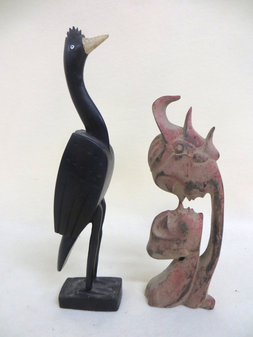 Two wooden folk art objects including carved ebony wood: Two wooden folk art objects including carved ebony wood bird with bone beak 11"H, and an Art Deco style carved figure of man and woman nose to nose, signed illegibly on base NY. 9"H.