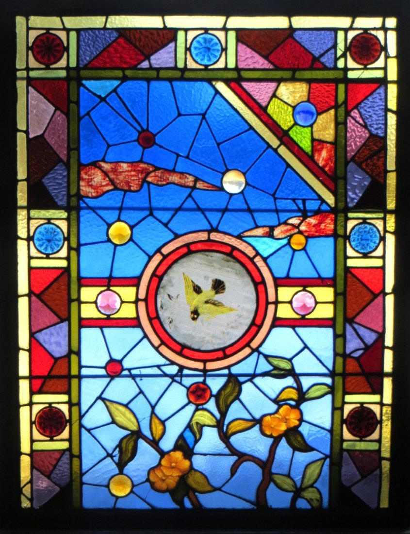 Beautiful stained and leaded glass window with round: Beautiful stained and leaded glass window with round bull's-eye inserts - central medallion of hand painted bird - stained glass in geometric patterns - 36" x 45.5". Some panels with cracks in glass b