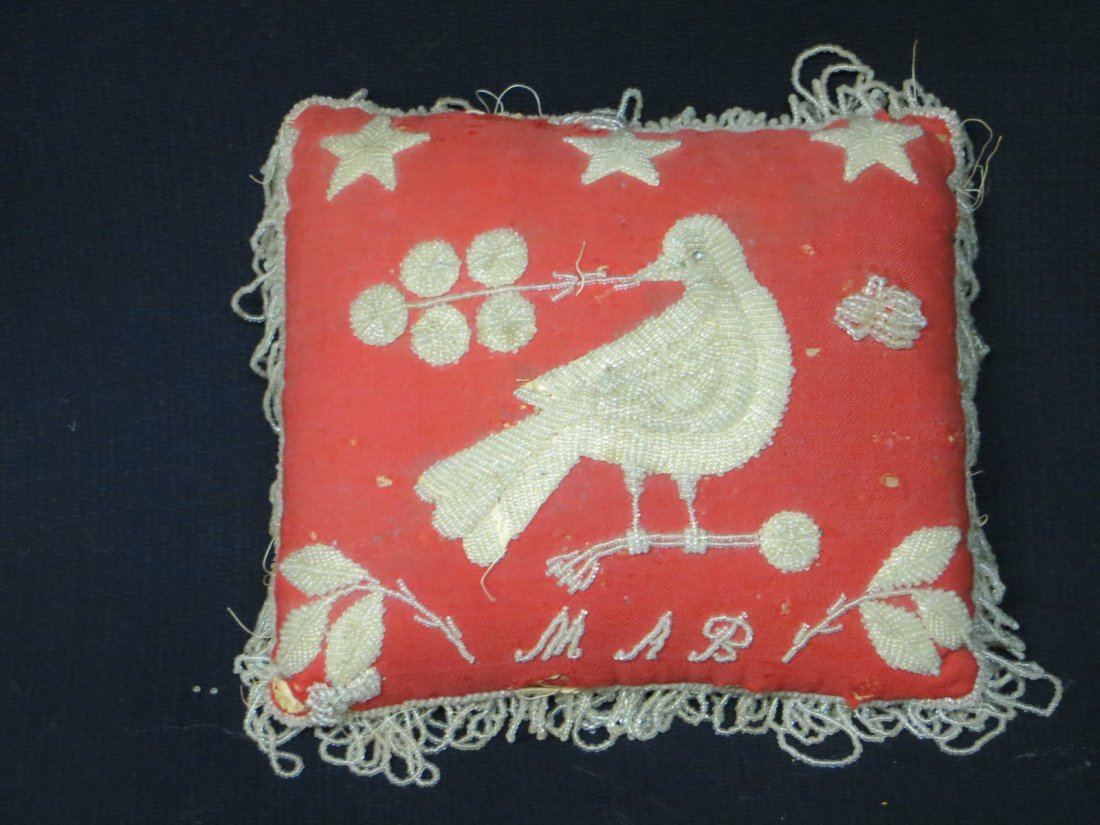 Native American beadwork pincushion decorated with: Native American beadwork pincushion decorated with stars, leaves and bird on branch signed in beadwork M.A.B.- some moth damage to background otherwise good condition - 7.5"L x 6'5"W.