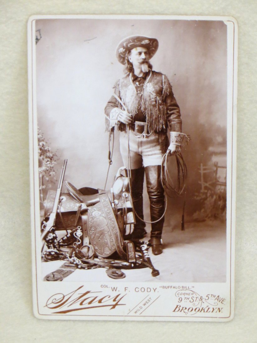 Cabinet card souvenir photo of Col. W. F. Cody "Buffalo: Cabinet card souvenir photo of Col. W. F. Cody "Buffalo Bill" holding a rope standing adjacent to his fancy tooled saddle with image of himself holding a rifle - his rifle is also laying on saddle in 