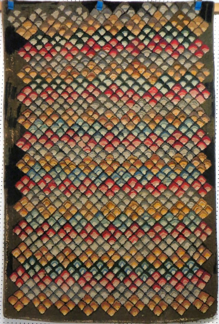 Large hooked rug decorated with fans within a diamond: Large hooked rug decorated with fans within a diamond and a saw tooth border - 2 old repairs on reverse and 2 nickel size holes otherwise good overall condition - late 19th century - 51" x 78".