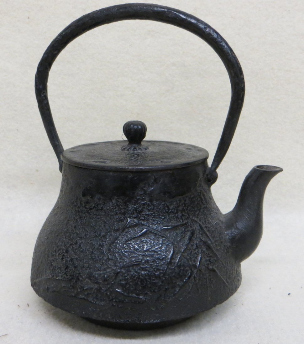 Diminutive 19th C Cast iron tea kettle with a bamboo: Diminutive 19th C Cast iron tea kettle with a bamboo and bird embossed side, signed by maker right of spout, small bud at finial overall 6.75 inches to top of wrought iron handle