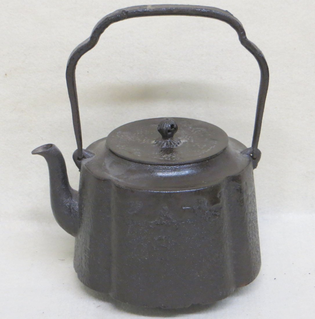 Cast iron Tea Kettle with scalloped textured sides: Cast iron Tea Kettle with scalloped textured sides finial on lid - signed by maker, right of spout - several minor chips on base otherwise good condition. Overall height is 10 inches to top of cast ir