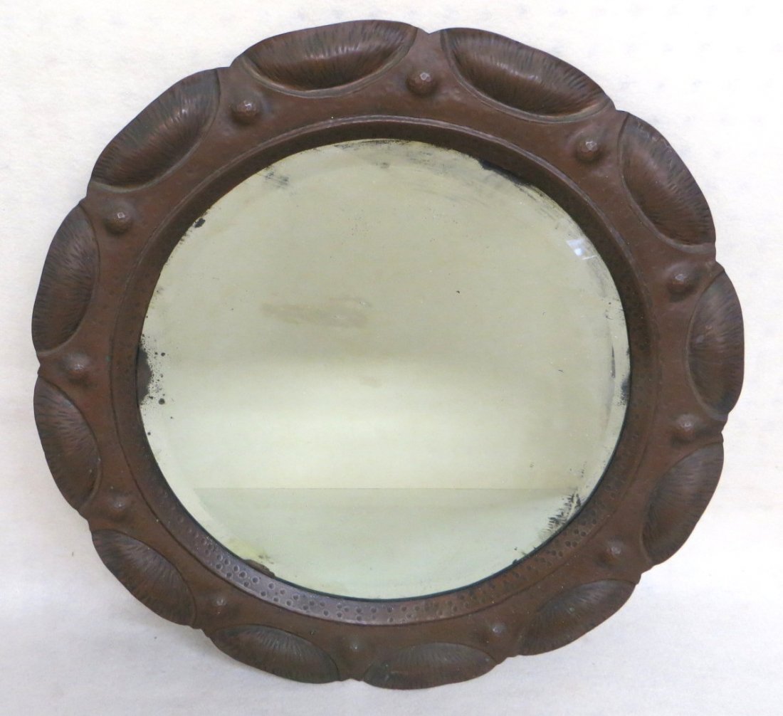 Arts and crafts hand hammered copper framed mirror with: Arts and crafts hand hammered copper framed mirror with round beveled glass mirror - tin backing holds the mirror in place - appears to retain original mirror - early 20th century - 21.75"D.