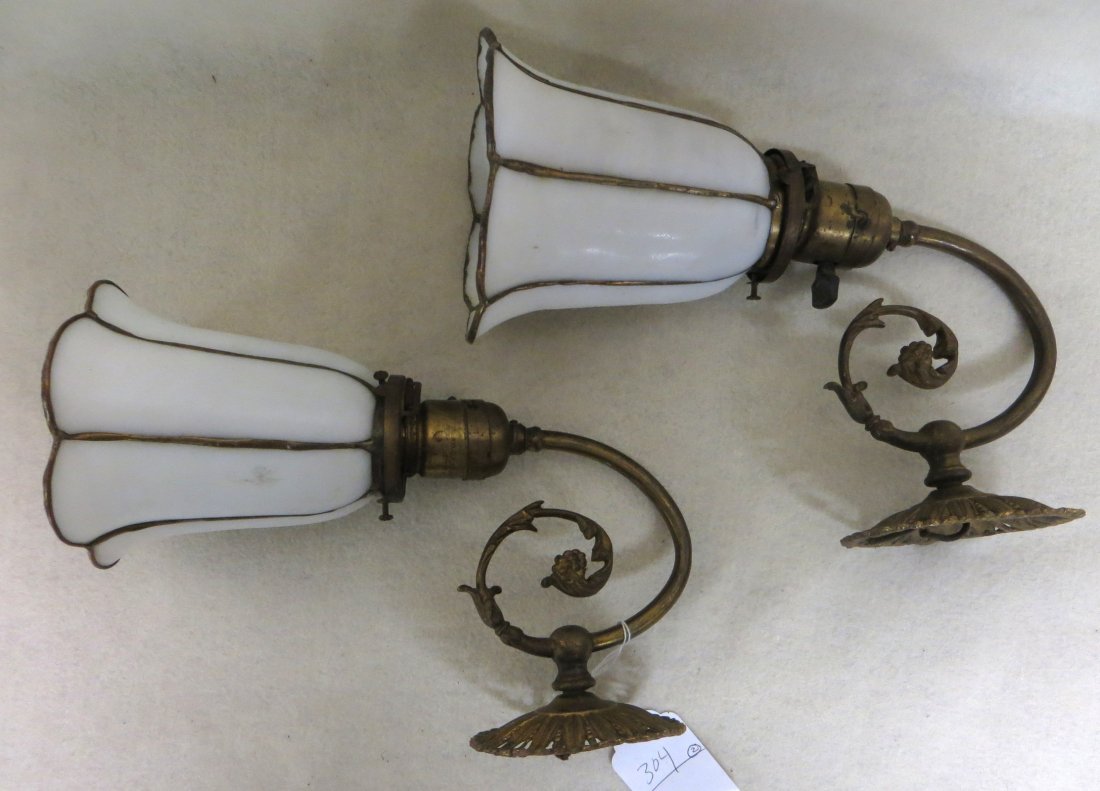 Pair of brass electric wall sconces with leaded milk: Pair of brass electric wall sconces with leaded milk glass shades - circa 1920 - 11"H. Both in good condition.