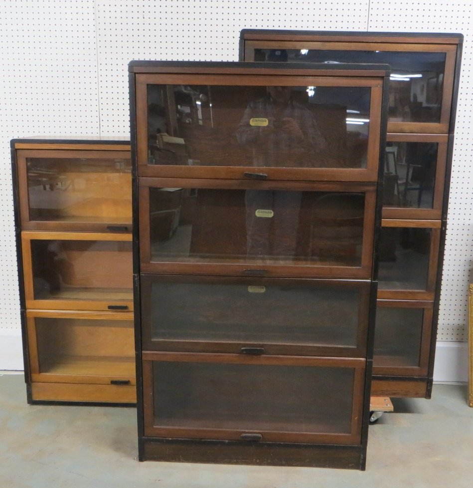 Three stacking barrister bookcases, including 2 four: Three stacking barrister bookcases, including 2 four sections (birch stained mahogany) and 1 three section (lighter wood), all Lundstrom - one with damaged base.