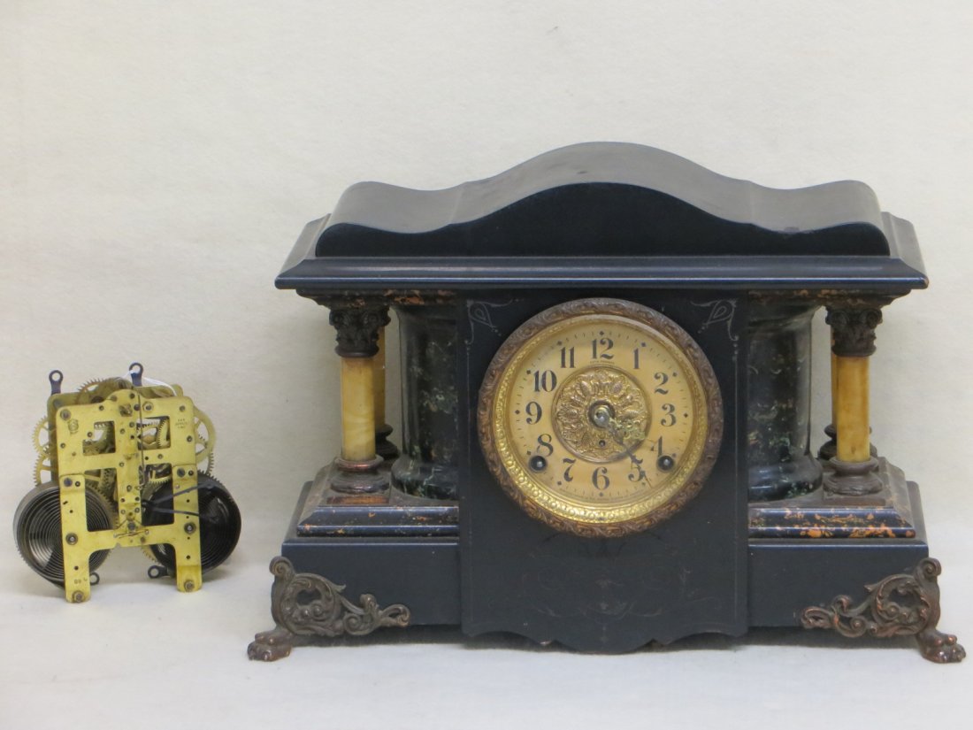 Seth Thomas mantel clock in ebonized wood with faux: Seth Thomas mantel clock in ebonized wood with faux marble pillars comes with an extra set of Seth Thomas brass works, clock being sold as non working order.