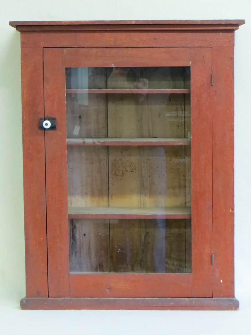 Primitive wooden wall cupboard with single glass pane: Primitive wooden wall cupboard with single glass pane door in original red paint - mid to late 19th century - 33"H x 28.25"W x 9"D - 4 interior shelves. Very good overall condition.