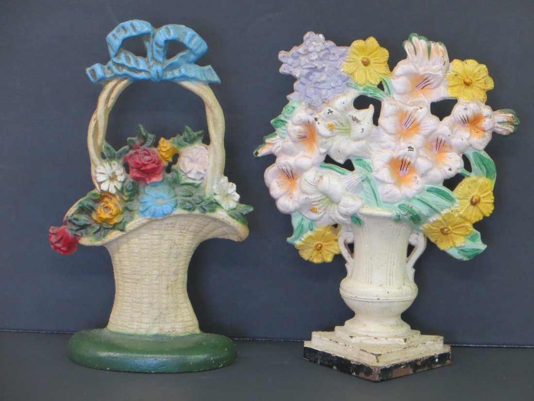 Two cast iron doorstops including flowers in an urn: Two cast iron doorstops including flowers in an urn numbered 489 with a triangular base 10" H, and a John Wright flower basket with a bow topper 10.25" H. Both in good original paint.