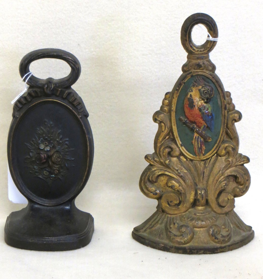 Two cast iron doorstops one signed Bradley & Hubbard of: Two cast iron doorstops one signed Bradley & Hubbard of a Medallion on base with a floral center under a ribbon and bow handle 7.5" H, the second an ornate scrolled base holding a medallion with a Par