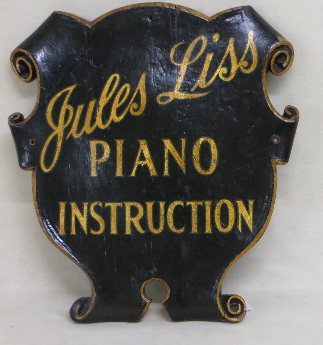 Old piano teacher's sign "Jules Liss, Piano: Old piano teacher's sign "Jules Liss, Piano Instruction" black base paint with gold script and block lettering - painted gold accents at scrolled edges. 19.25" W X 20.25" H.