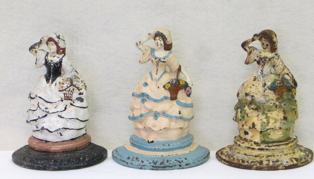 Three cast iron doorstops of a Lady with a basket of: Three cast iron doorstops of a Lady with a basket of flowers holding her bonnet all in old paint 6.75"H X 5" W