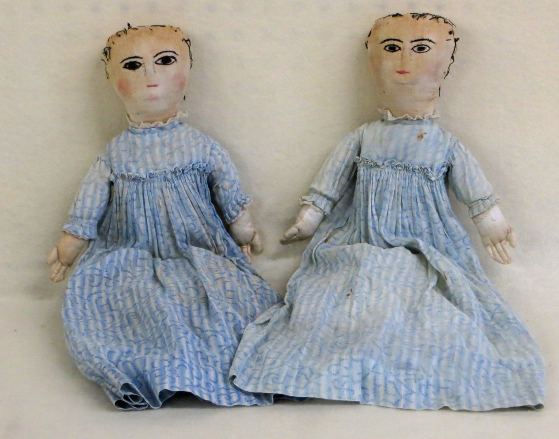 Two twin cloth dolls in original costumes with hand: Two twin cloth dolls in original costumes with hand embroidered faces - late 19th to early 20th century - missing bonnets - dresses and white under garments with minor stains - 17"H.